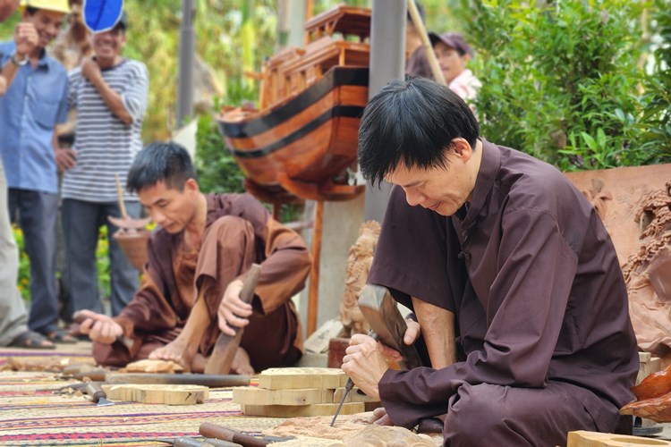 Skilled artisans demonstrating traditional wood carving techniques at Kim Bong Carpentry Village