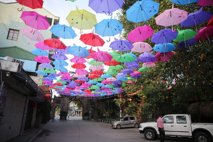 The glittering Umbrella Street impresses tourists in Van Phuc Silk Village.
