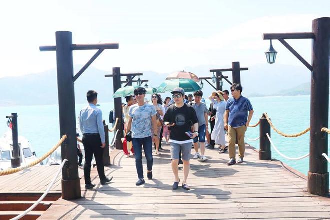 Tourists enjoying sunny weather at a less crowded Nha Trang beach in October, perfect for affordable travel.