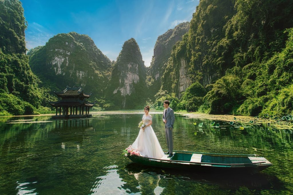 View of Ninh Binh's beautiful landscapes during the spring season, highlighting lush greenery and clear skies under the golden sunlight.