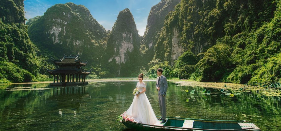 View of Ninh Binh's beautiful landscapes during the spring season, highlighting lush greenery and clear skies under the golden sunlight.